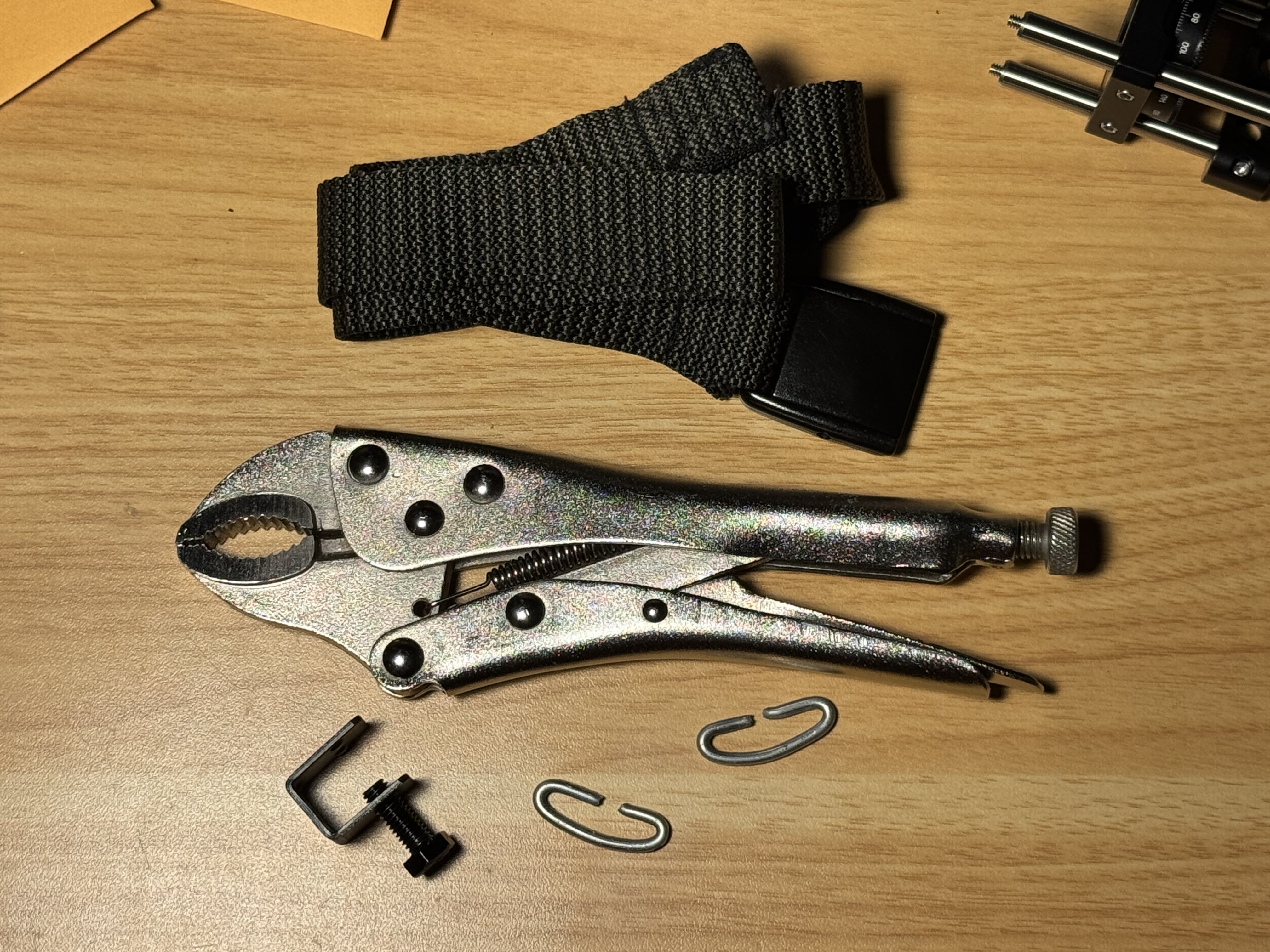 Nylon belt, metal clips made from thick gardening wire, a small screw clamp, and locking pliers