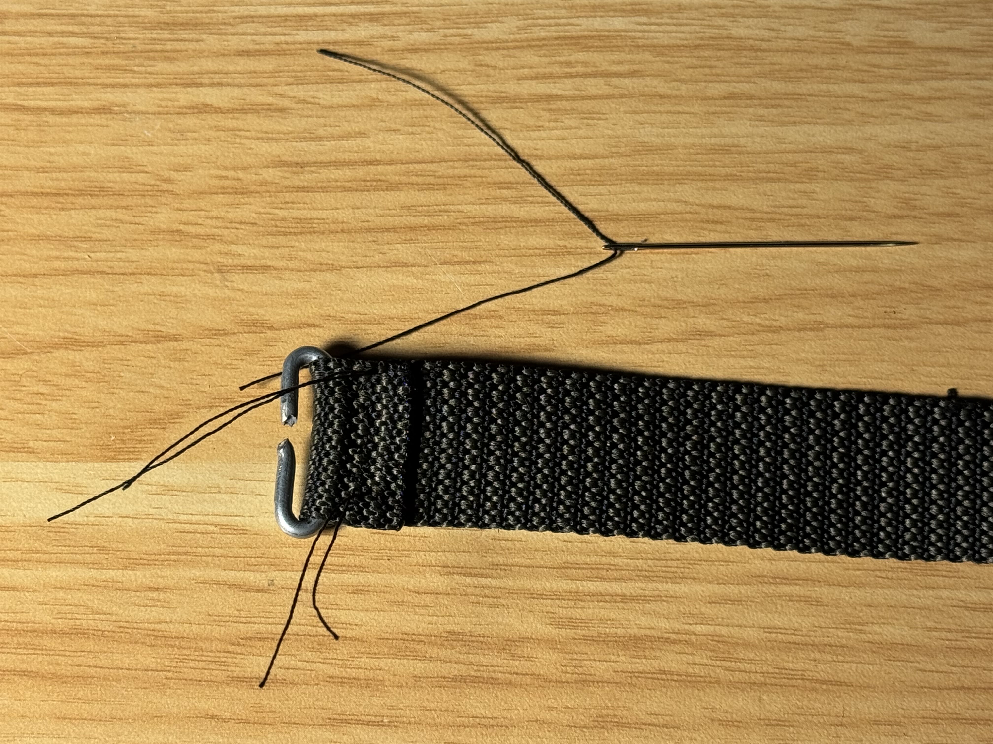 Sewing one of the cut ends of the nylon belt to one of the metal clips